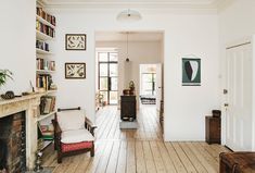 a living room filled with furniture and a fire place next to a fireplace covered in books