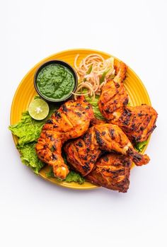 grilled chicken and vegetables on a yellow plate with green sauce, cilantro