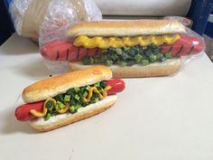 two hot dogs on buns with toppings and ketchup are sitting next to each other