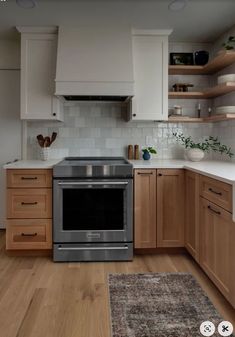 a kitchen with wooden cabinets and stainless steel stove top oven in the middle of it