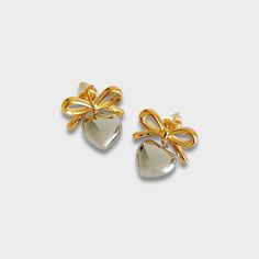 For all those bow and heart lovers! Bow stud with silver puff heart charm. 18k gold plated stainless steel Silver heart charm Diameter: 20 x 22mm Tarnish and sweat resistant Hypoallergenic no green skin 1 year warranty Silver Heart-shaped Gold-plated Earrings, Heart-shaped Metal Earrings For Mother's Day Gift, Silver Gold-plated Heart Earrings For Gifts, Silver Gold Plated Heart Earrings Gift, Gift Silver Gold Plated Heart Earrings, Gold Heart Metal Earrings For Gift, Gold Metal Heart Earrings For Gift, Gold Metal Heart Earrings As Gift, Cute Gold Heart Earrings For Mother's Day