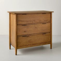 a wooden dresser sitting on top of a white floor