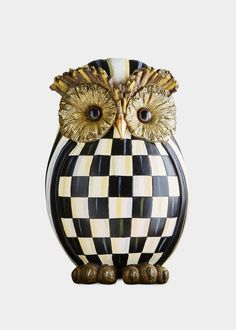 an owl figurine sitting on top of a checkered surface