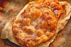 two pastries sitting on top of a piece of wax paper