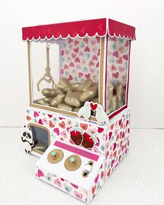 a cardboard box filled with donuts and other treats on top of a white table