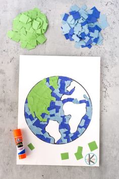 the earth is made out of pieces of paper and colored crayons next to it