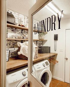 a washer and dryer in a small room with shelves full of laundry items