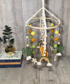 a wind chime hanging from the ceiling next to some books and a potted plant