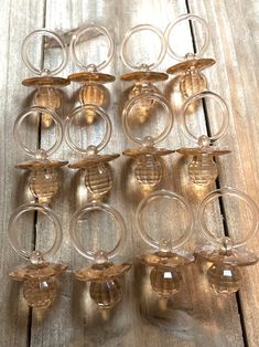 twelve clear glass candlesticks on a wooden table with one candle holder in the middle