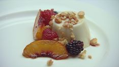 a white plate topped with dessert and fruit on top of it's side covered in crumbs