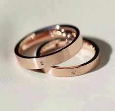 two wedding rings sitting on top of each other