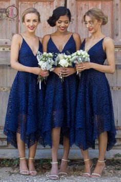 three women in dresses standing next to each other with flowers on their laps and holding bouquets