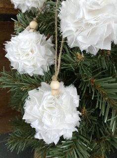 some white flowers hanging from a christmas tree