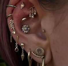 a close up of a person's ear with various piercings on it and one behind the ear