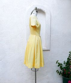 Lemon yellow 60's dress with scalloped neckline and sleeves. This pretty dress is made from soft, textured cotton. It has short sleeves and a back metal zipper. It has a natural waistline. The skirt has wide pleats and falls below the knee. Lovely for a casual or formal event. Fits up to a size 6. The dress form is a 4. Measurements with room for comfort: Bust up to: 35 inches. Waist up to: 26 inches. Hips free. Exact measurements taken flat to compare to a garment which fits well: Length: 39 in Yellow Pleated Short Sleeve Dress, Yellow Pleated Dress For Daywear, Short Sleeve Dresses With Box Pleat For Daywear, Retro Short Sleeve Dress With Pleated Waist, Event Fits, Scalloped Neckline, 60's Dress, Wedding Sale, Mount Pleasant