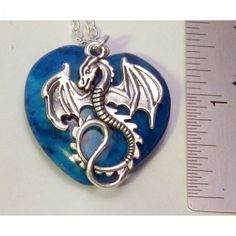 Dragon and Light Blue Riverstone Heart Necklace A soaring winged silvertone dragon and Light blue Riverstone heart stone. In modern times dragons have remained an important part of our culture. Dragons represent luck, power and strength A blue heart can be used to express love, support, admiration, happiness, and excitement create a “Dragon Love” necklace. A unique way to wear and display your dragon. * A dyed quartz gemstone pendant * 1.25 inch (3.5 cm) silver tone dragon * 1.25 inches x 1.25 i Personalized Blue Heart Pendant Jewelry, Valentine's Day Themed Heart Jewelry, Valentine's Day Heart Shaped Themed Jewelry, Valentine's Day Heart-shaped Themed Jewelry, Unique Blue Jewelry With Heart Charm, Blue Personalized Heart Pendant Necklace, Personalized Blue Heart Jewelry, Handmade Blue Fantasy Jewelry, Personalized Blue Heart-shaped Jewelry