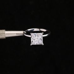 a white gold ring with a princess cut diamond