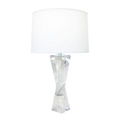 a lamp that is on a table with a white lampshade in front of it