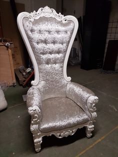 an ornate white chair sitting on top of a floor