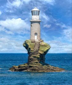 a light house sitting on top of a rock in the ocean