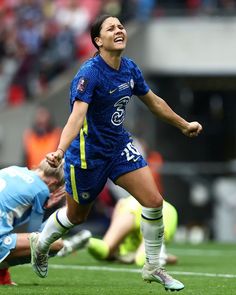 a female soccer player is running after the ball and has her mouth wide open as she celebrates