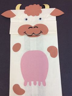 a paper bag with a cow cut out on it's side and eyes painted pink