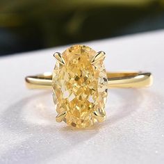 a yellow diamond ring sitting on top of a table