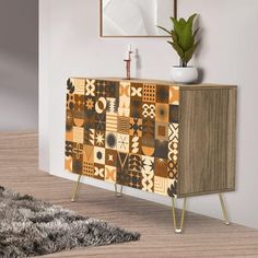 a brown and white patterned cabinet next to a potted plant on top of a wooden table