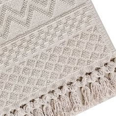 a white blanket with fringes on it