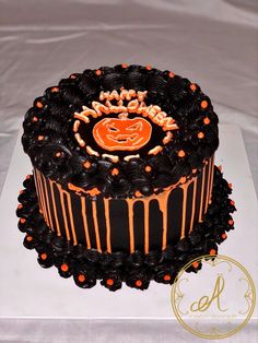 a halloween cake decorated with black icing and orange sprinkles on top