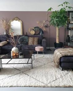 a living room filled with furniture and a large mirror on the wall above it's headboard