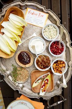 an assortment of food is displayed on a silver platter, including apples, cranberries, and other foods