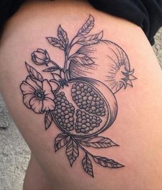 a woman's thigh with a pomegranate tattoo on it