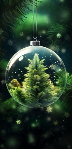 a christmas ornament hanging from a tree with snowflakes on the ground