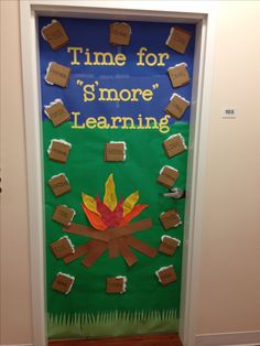 a door decorated to look like a campfire with the words time for s'more learning on it