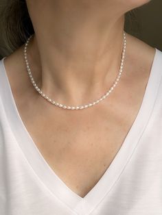 Add a touch of elegance to your outfit with this dainty string of pearls beaded choker necklace. Crafted with small, tiny freshwater rice pearls, this minimal jewelry piece exudes sophistication and charm. The 14k gold filled accents bring a subtle hint of luxury to the delicate design. Perfect for layering or wearing on its own, this thin pearl necklace is a versatile addition to your accessory collection. Upgrade your style with this timeless and classic piece today. * Rice Pearl beads measure Rice Pearls, String Of Pearls, Hypoallergenic Jewelry, Minimal Jewelry, Necklace Beaded, Beaded Choker Necklace, Pearl Gemstone, June Birth Stone, Beaded Choker