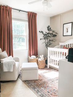 a baby's room with a crib, chair, and ottoman in it