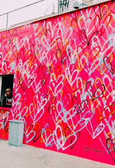 a pink wall with lots of graffiti on it