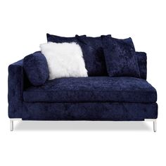 a blue velvet couch with white pillows on it's arms and backrests