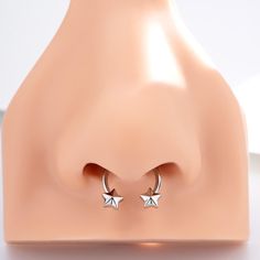 two small silver stars are attached to the back of a pair of ear studs