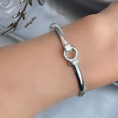 All handmade in solid 925 sterling silver, the circle detail has a cleverly disguised clip that has a double ribbon effect which you can undo to slip the bangle on the wrist and then fasten again for security. Diameter: 57 x 47 mm.  Top Width: 10 mm.   Thickness: Bangle: 3.5 mm.   With your first purchase, we shall be sending you a free gift from our silver jewellery collection to the value of £25 White Topaz Earrings, Boho Bangle, Handmade Bangles, Sapphire Bracelet, Topaz Earrings, Sterling Silver Bangles, Cuff Bangles, Polish Jewelry, Silver Bangles