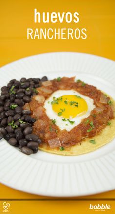 a white plate topped with black beans and an egg