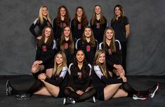 the volleyball team is posing for a group photo in black and white uniforms with red numbers