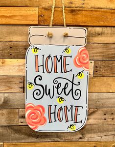 a sign hanging on the side of a wooden wall that says, home sweet home