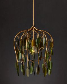 a chandelier with green glass leaves hanging from it's gold metal frame