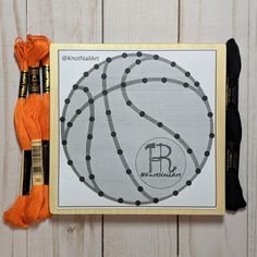 an orange skeinkle next to a basketball on a white wooden background with black dots