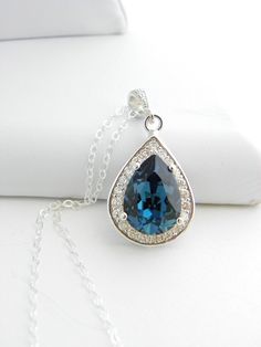 "This sparkly necklace has been made with a custom frame, only available in our shop! The rhodium plated frame has around 20 small clear cubic zirconias and the focal is a sparkly Montana Blue color Swarovski teardrop. This luxury necklace is perfect for a fancy night out, great as focal point of your outfit or for Bridesmaids gift. The swarovski teardrop crystal measures 18mm and the whole pendant including the Cubic Zirconia Drop setting about 1\" (25mm) in total length. Comes on a 18 inch ste Blue Necklace With Halo Setting For Wedding, Blue Halo Setting Necklace For Wedding, Blue Wedding Necklace, Business Capsule, Business Capsule Wardrobe, Swarovski Jewelry Necklace, Blue Pendant Necklace, Sparkly Necklace, Necklace Bridal