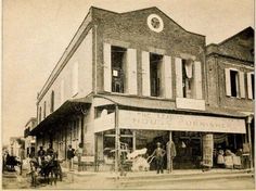 an old black and white photo of people in front of a building