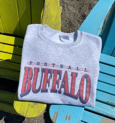 This Vintage Football Crewneck Sweatshirt is a must-have for any retro sports fan! Made with a high-quality sublimation print on a soft and cozy 50/50 cotton/polyester blend crewneck sweatshirt, this shirt is built to last. Available in sizes small through 5X, it's size-inclusive and perfect for anyone who loves a vintage aesthetic. Product Description: -Vintage-inspired football design -Size-inclusive, available in small through 5X -Sublimation printed on soft 50/50 cotton/polyester blend crewn Throwback Tops With Letter Print For Sports Events, Cotton Sublimation Crew Neck For Sports Season, Casual Sublimation T-shirt For Fan Merchandise, Casual Sublimation Design For Fan Merchandise, Sporty Graphic Print Sweatshirt For Fans, Sporty Sublimation Crew Neck With Letter Print, Sublimation Crew Neck Design For Sports Events, Crew Neck Sublimation T-shirt For Sports Events, Gray Letter Print Sweatshirt For Game Day