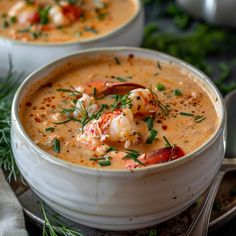 two white bowls filled with soup and garnished with shrimp